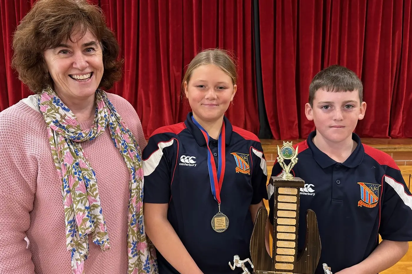 Narrandera\\u2019s St Josephs Catholic School Mrs Marie O\\'Brien, Lexxis Cottom-Fuller and Max Smith with the overall house trophy, which was awarded to Tenison.