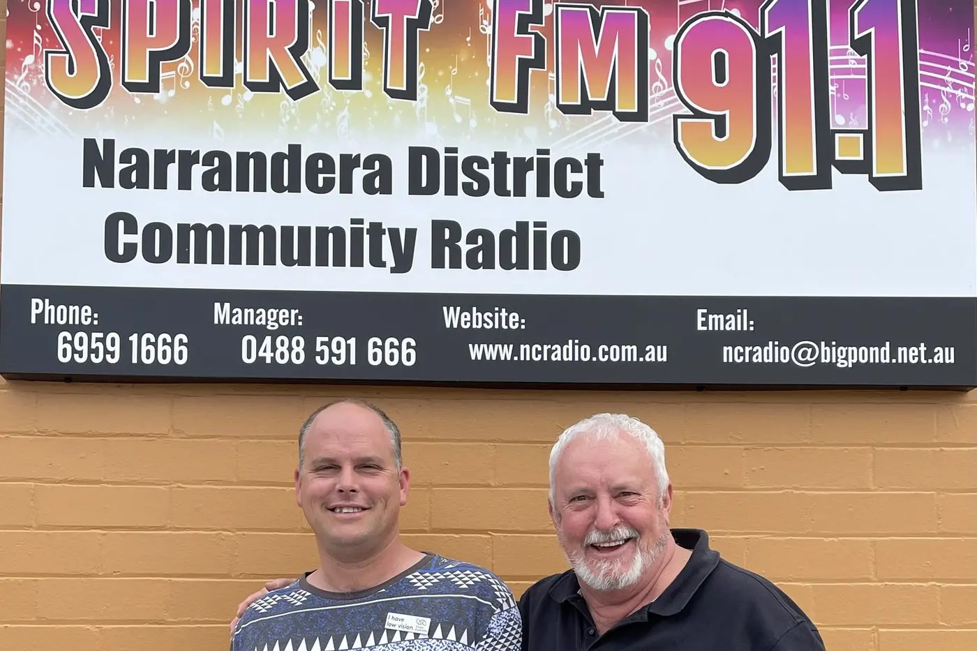 \\u2018Captain and The Fatman\\u2019 (Spirit FM 91.1 presenters Tim and Jock Wright) showing off the new-look sign designed and installed by Narrandera Signs.