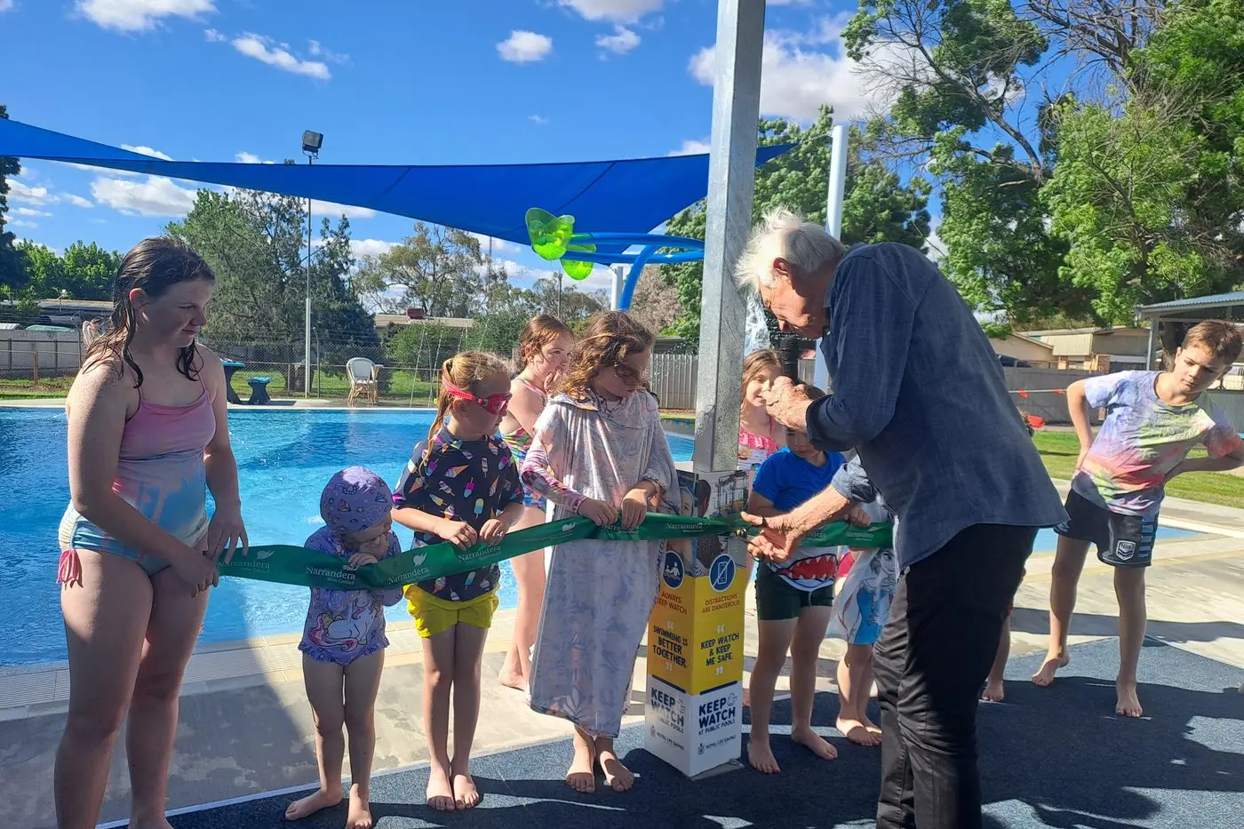 Narrandera Shire Mayor Neville Kschenka cuts the ribbon at the official opening of the toddlers pool at the Barellan Swimming Pool complex last weekend.