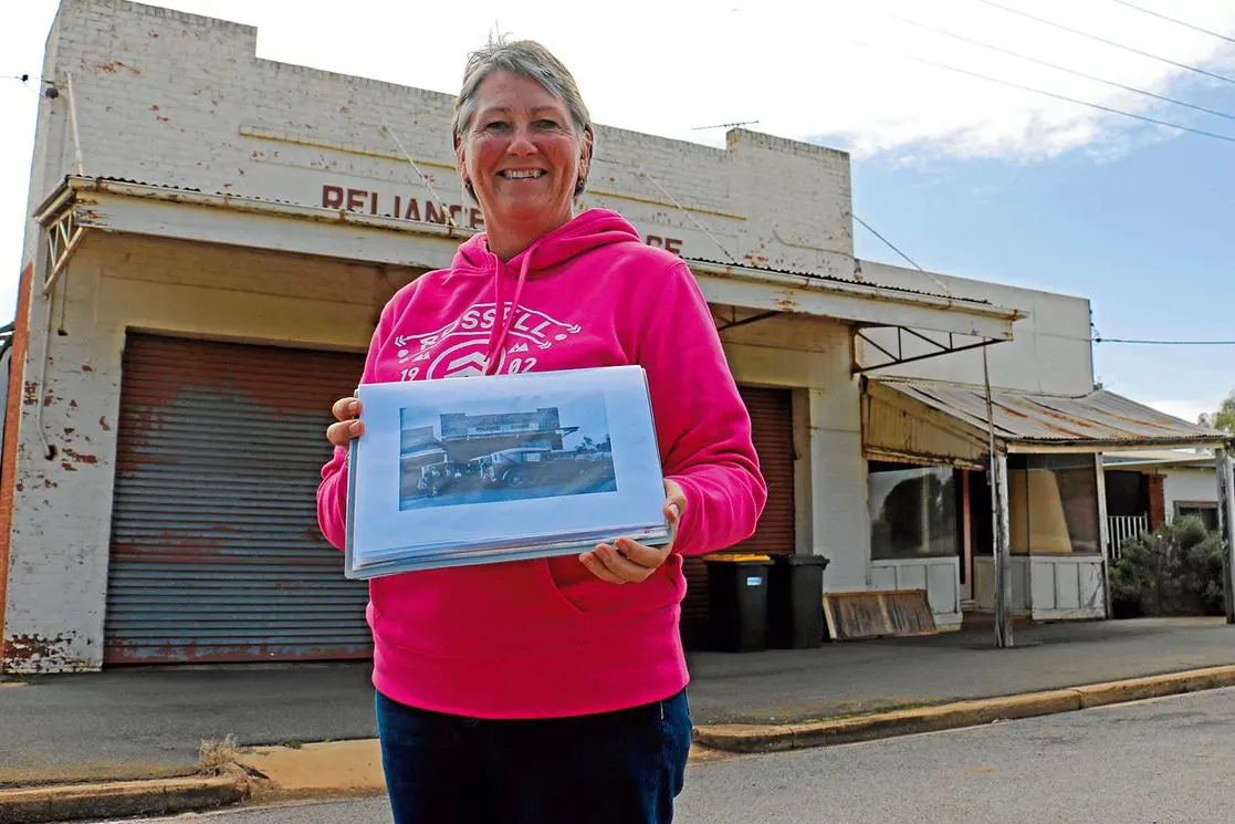 Kerryn Cassidy outside of the Reliance Garage, run by the Choy family, and to be part of the historic sign trail. Photo: Kim Woods