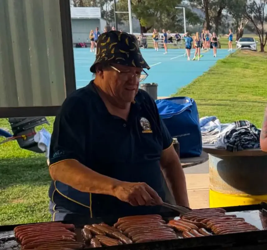 Volunteer honoured after cooking 80,000 snags for footy club over 21 years