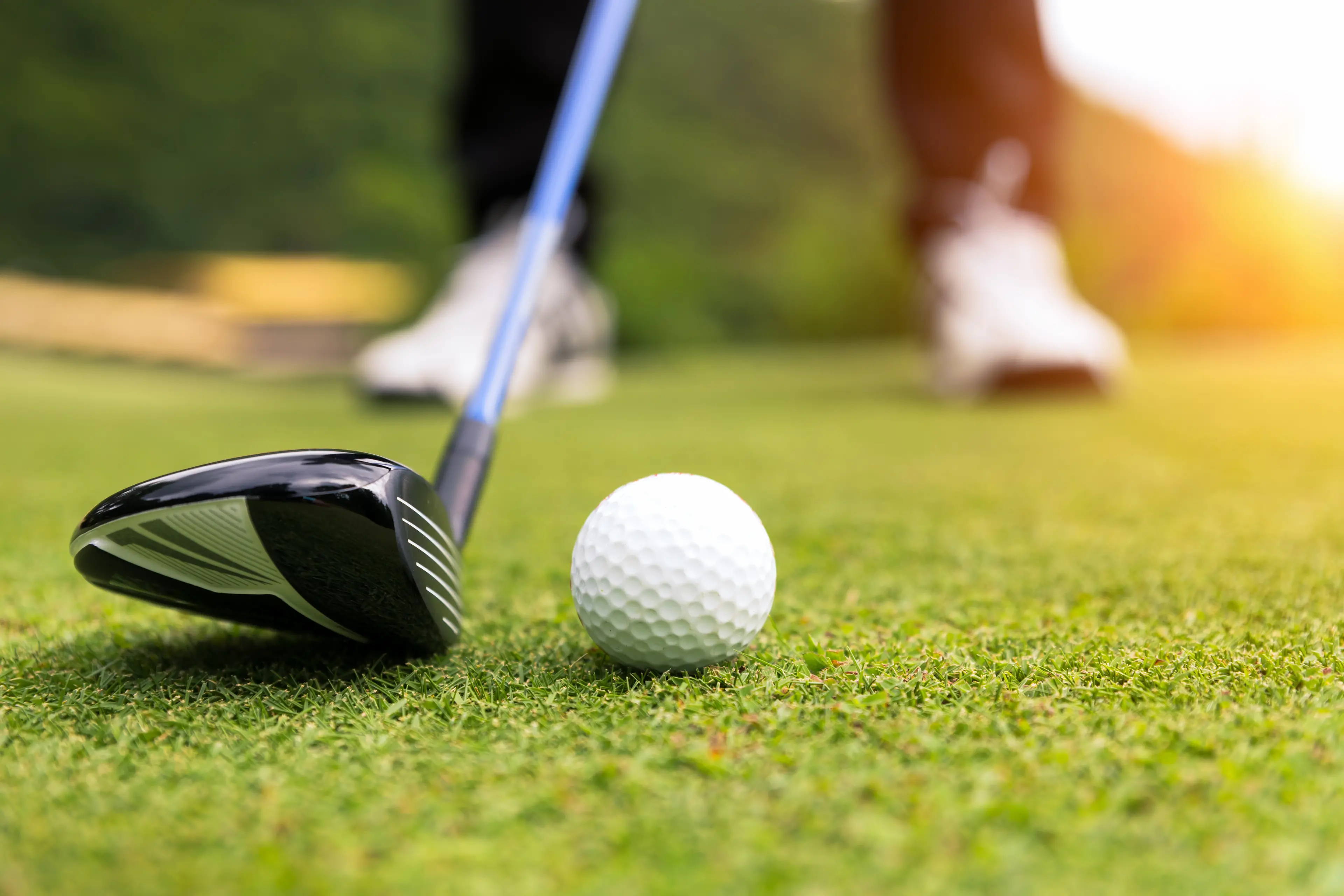 Golf ball on green grass ready to be struck at golf club,close up in golf coures at Thailand